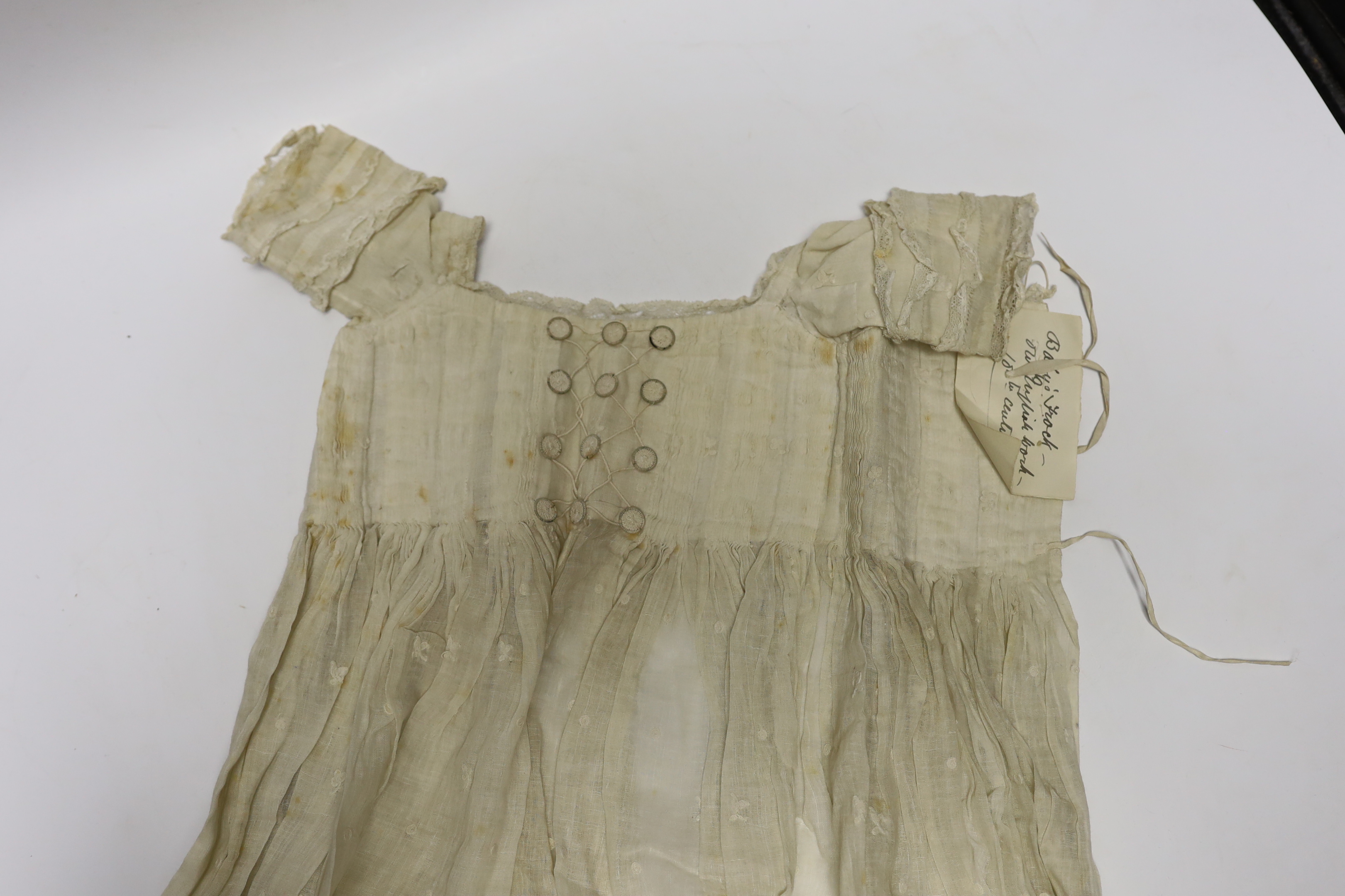 An early 18th century Hollie point insertion baby’s linen vest, three baby bonnets with Hollie point insertions and an early 18th century pair of Flemish bobbin lace lappets, a partly finished needlepoint length of lace,
